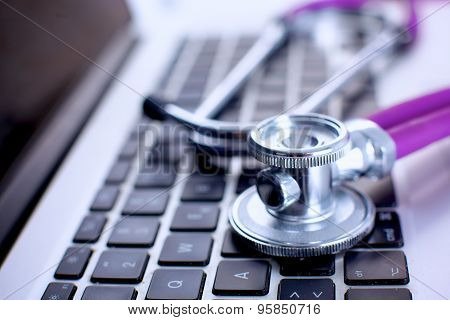 Violet stethoscope on a laptop computer