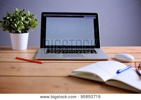 Laptop stands on a wooden table
