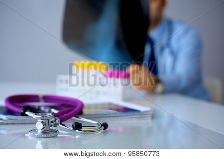 Medical doctor  sitting at table and looking patients roentgen