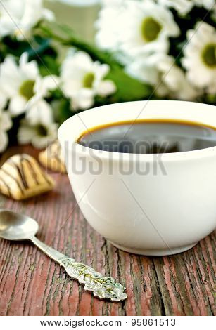 Coffee with flowers on wooden table