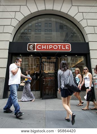 NEW YORK CITY - FRIDAY, JUNE 19, 2015: Pedestrians walk past a Chipotle fast food restaurant. Chipotle Mexican Grill, Inc. is a chain of restaurants