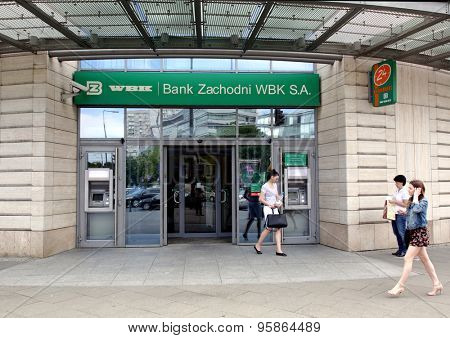 WARSAW, POLAND - SATURDAY, JUNE 6, 2015: Pedestrians walk past a Bank Zachodni WBK branch. Bank Zachodni WBK (BZ WBK) is the third largest bank in Poland  
