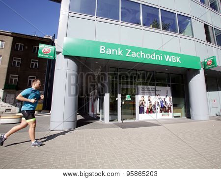 WARSAW, POLAND - SATURDAY, JUNE 6, 2015: Pedestrians walk past a Bank Zachodni WBK branch. Bank Zachodni WBK (BZ WBK) is the third largest bank in Poland  