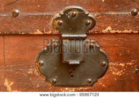 Front view of vintage worn-out leather suitcase with metallic lock in retro style