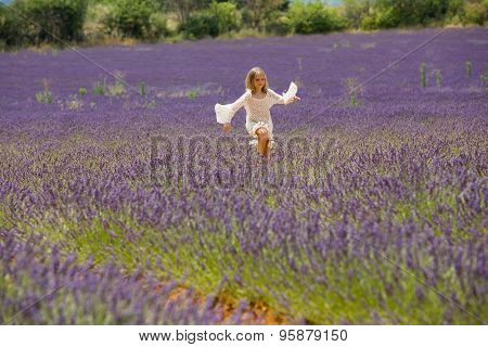 Beautiful blonde girl jumps in lavender field