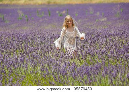 Beautiful blonde girl walk in lavender field