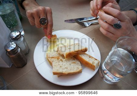 Female hands dipping Italian bread into olive oil at a restaurant