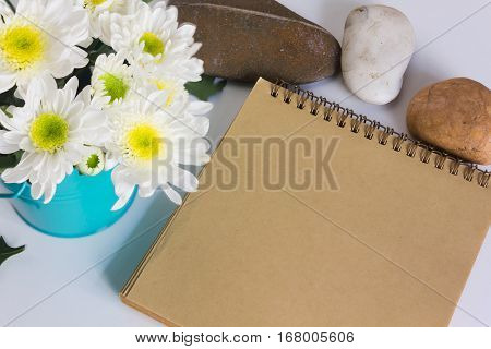Blank Area Note Book Or Diary With Flower And Pebble