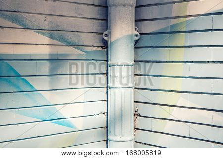 white and blue painted wall corner with a gutter