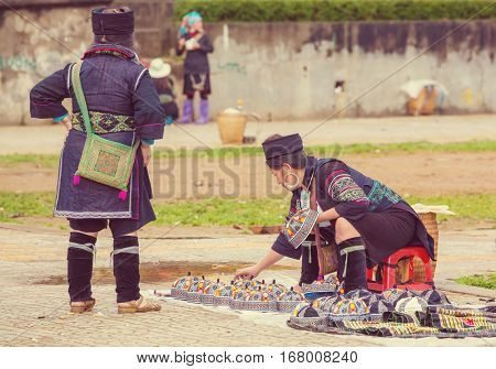 SAPA, VIETNAM - OCTOBER 29, 2012: Hmong women sell souvenirs in Sapa. The Hmongs are known for their colorful clothes and silver jewelry. Hmong women have various clothes colours and style