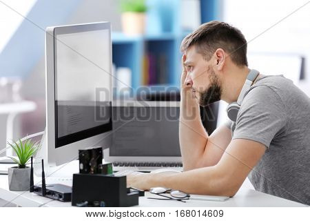 Handsome young programmer working at home