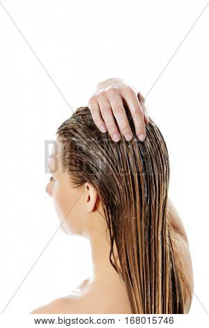 Photo of woman applying hair conditioner.