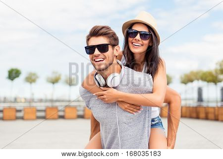 Handsome Man Carring His Smiling Girlfriend On Back