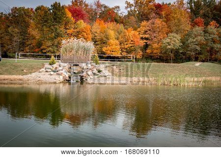 Faded fall landscape with pond reflection and color