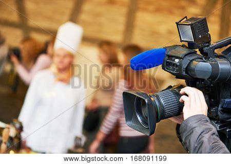cameraman operating video camera at news event