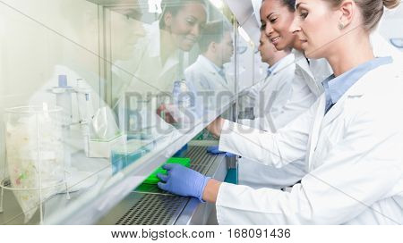 Group of scientists in research laboratory working under splashback