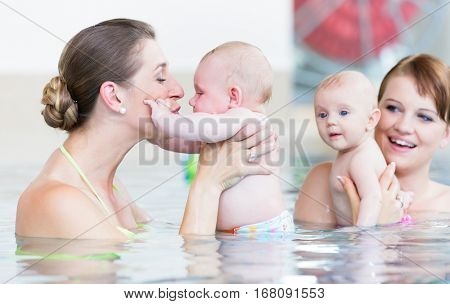 Newborns and their mums at infant swimming course  