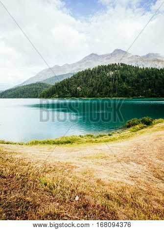 Great view of the azure pond Champfer in alpine valley. Picturesque and gorgeous scene. Location Swiss alps, Silvaplana village. Europe. Retro and vintage style. Instagram toning effect. Beauty world.