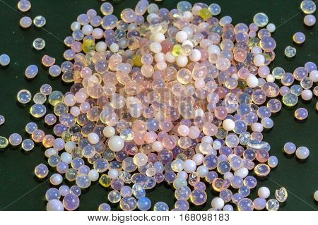 Macro of silica gel balls laying on black background.Its use to prevent mold, mildew, corrosion, odours and other moisture damage.