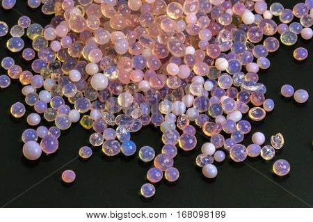 Macro of silica gel balls laying on black background.Its use to prevent mold, mildew, corrosion, odours and other moisture damage.