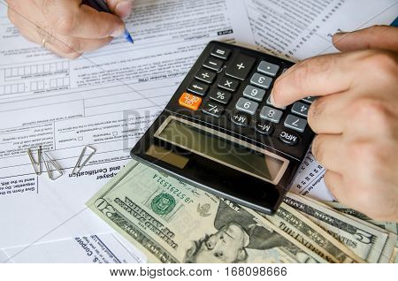 Cropped image of Businessman calculating and checking tax