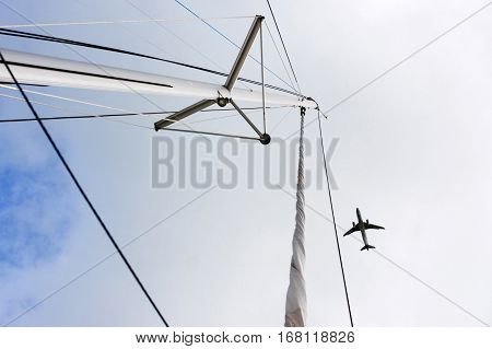 Plane over the mast. flying plane. Airplane and yacht