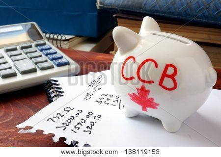 Piggy bank with word CCB. Canada child benefit concept.