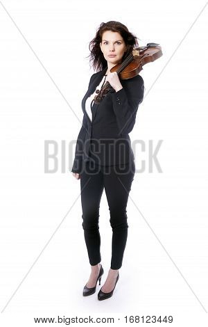 classical brunette beauty in suit holds violin on shoulder in studio against white background