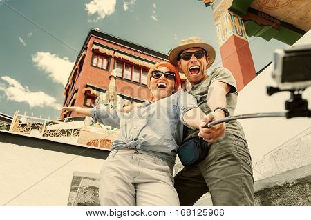 Happy tourist couple take a selfie photo on asian sight background