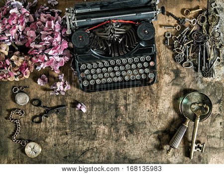 Vintage typewriter hortensia flowers and old keys on wooden table. Nostalgic still life