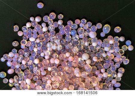 Macro of silica gel balls laying on black background.Its use to prevent mold, mildew, corrosion, odours and other moisture damage.