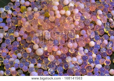 Macro of silica gel balls laying on black background.Its use to prevent mold, mildew, corrosion, odours and other moisture damage.