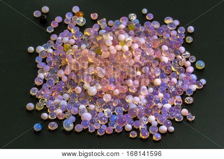 Macro of silica gel balls laying on black background.Its use to prevent mold, mildew, corrosion, odours and other moisture damage.