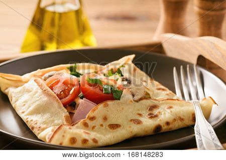 Pancakes sutffed with ham, cheese, tomatoes and mushrooms.