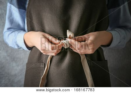 Woman  tying up her apron around the waist