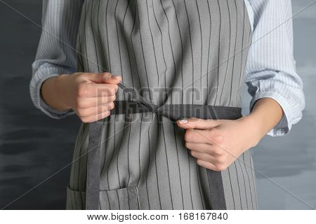 Woman  tying up her apron around the waist