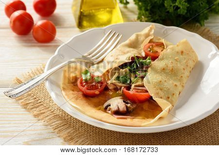 Pancakes sutffed with ham, cheese, tomatoes and mushrooms.
