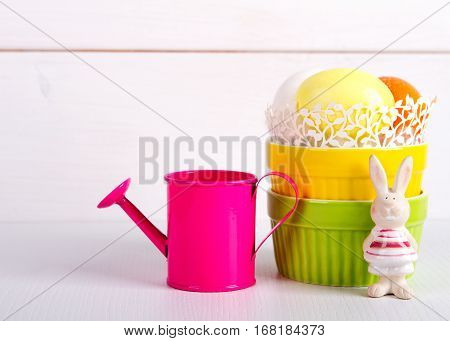 Easter holiday concept with a small watering can. egg and banny