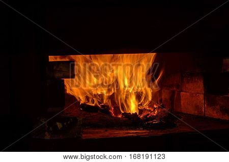 A coal forge in the blacksmith shop blazes
