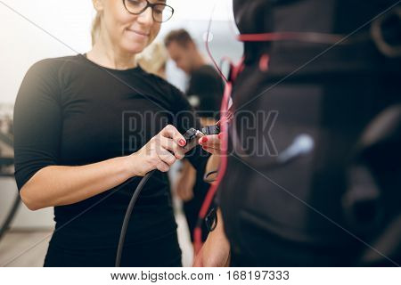 Happy Woman Connecting Cables Of Ems Suit