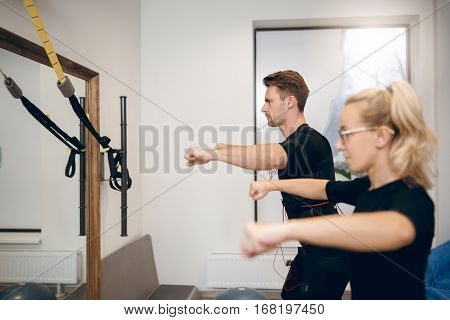 Concentrated Man Exercising With Personal Trainer