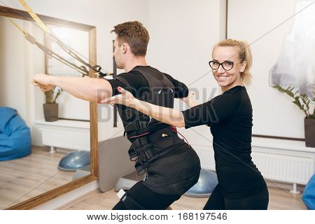 Happy Female Coach Training Man With Ems