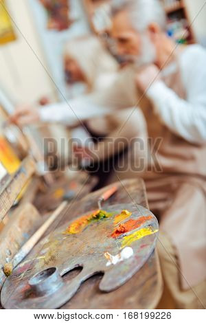 Work for art. Male talented concentrated artist drawing a picture while spending time in painting class and working.
