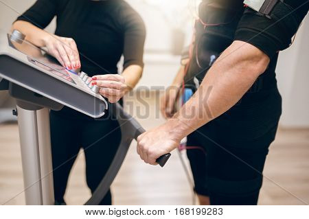 Sportsman Waiting For Personal Trainer To Turn On Ems Device