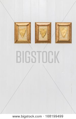 Gold Hearts Hanging On White Wooden Background. Copy Space.