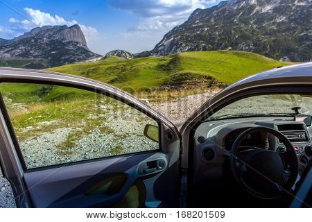 travel concept. the car with the door open on a background of mountains