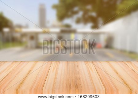 Wood table top on light blur Turnpike tolls background can be used for ad.