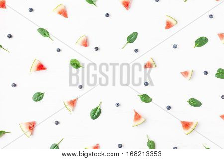 Watermelon slices blueberry and spinach leaves on white background. Summer concept. Flat lay top view