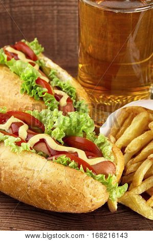 Hot Dogs With Glass Of Beer With French Fries On Wooden Board