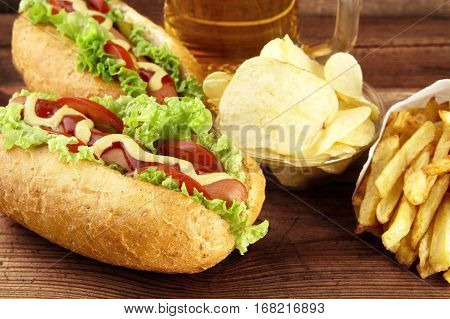 Hot Dogs With Glass Of Beer With Crisps,french Fries On Wooden B